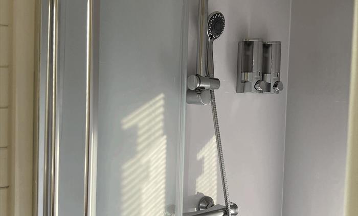shower unit with shower gel and soap dispensers on wall